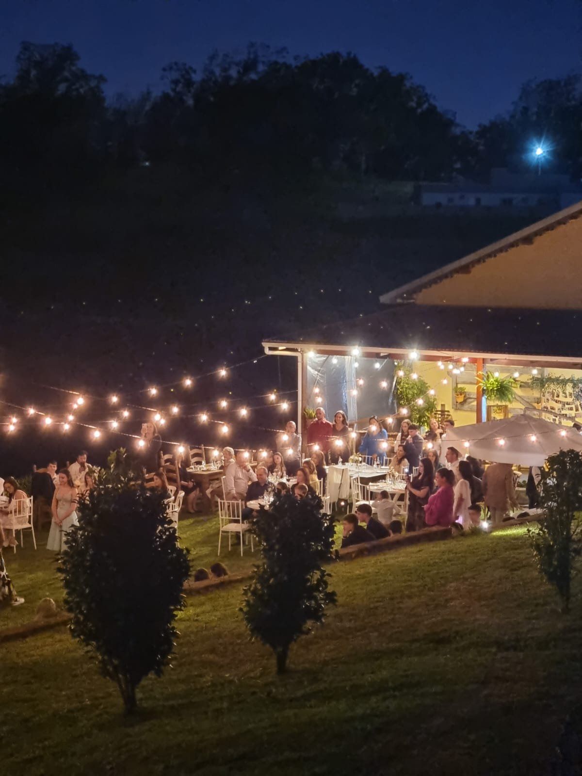 Casamento à noite no Beer Garden com varal de luzes sobre as mesas