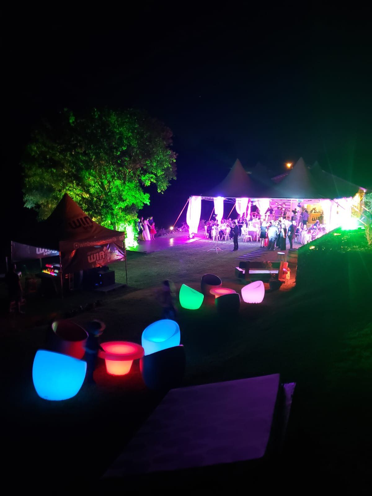 Festa noturna com tendas, banquetas de LED coloridas e tenda Win Beer